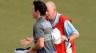 Rory McIlroy talks to caddie Dave Renwick on the 18th green after he was informed of a rules violation during the third round of the Abu Dhabi HSBC Golf Championship.