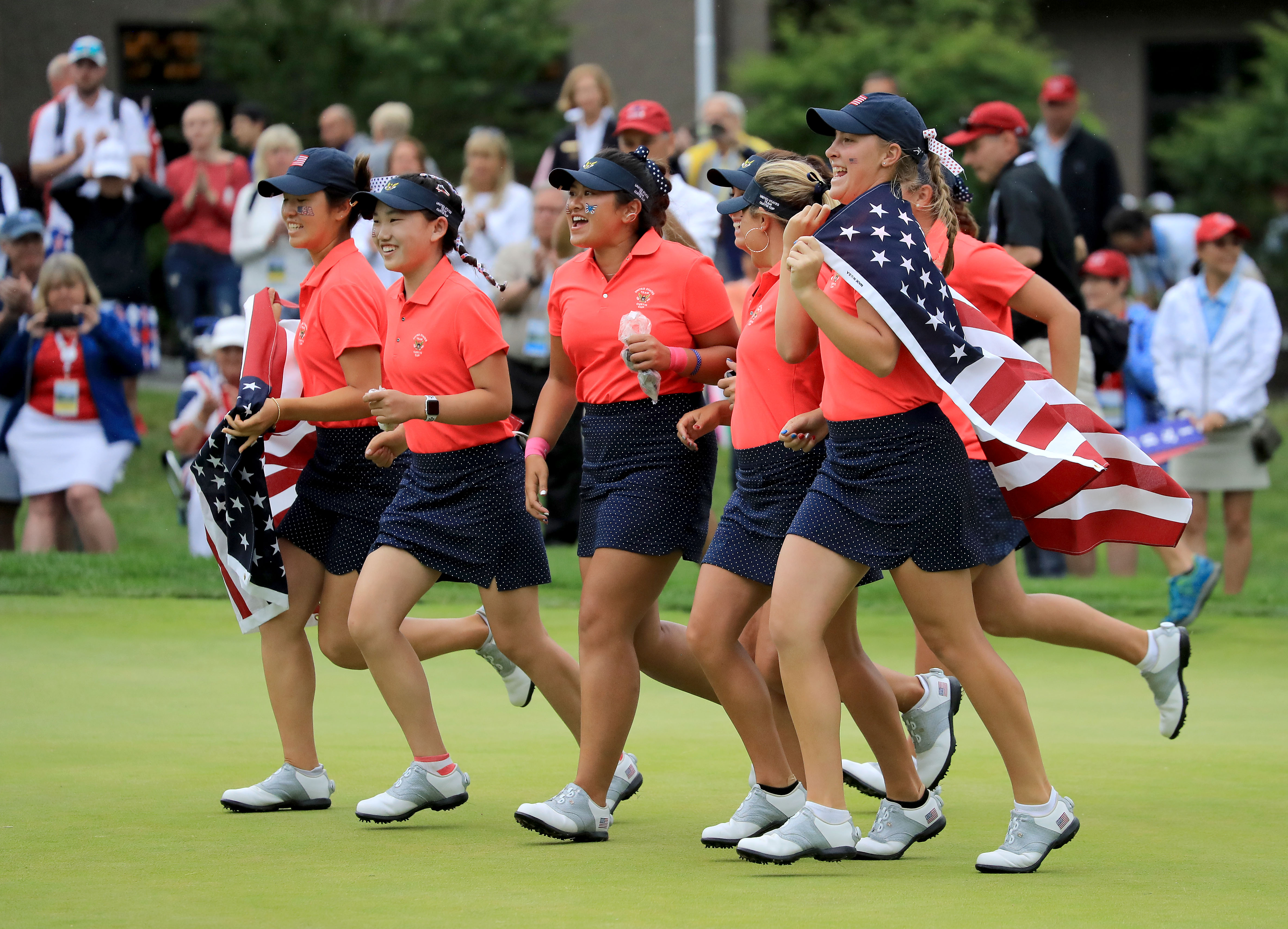 SCARSDALE, NY - JUNE 10: The United States team race onto the 18th green to celebrate after their 17-3 victory over the Gtreat Britain and Ireland team during the final day singles matches in the 2018 Curtis Cup Match at Quaker Ridge Golf Club on June 10, 2018 in Scarsdale, New York. (Photo by David Cannon/Getty Images)