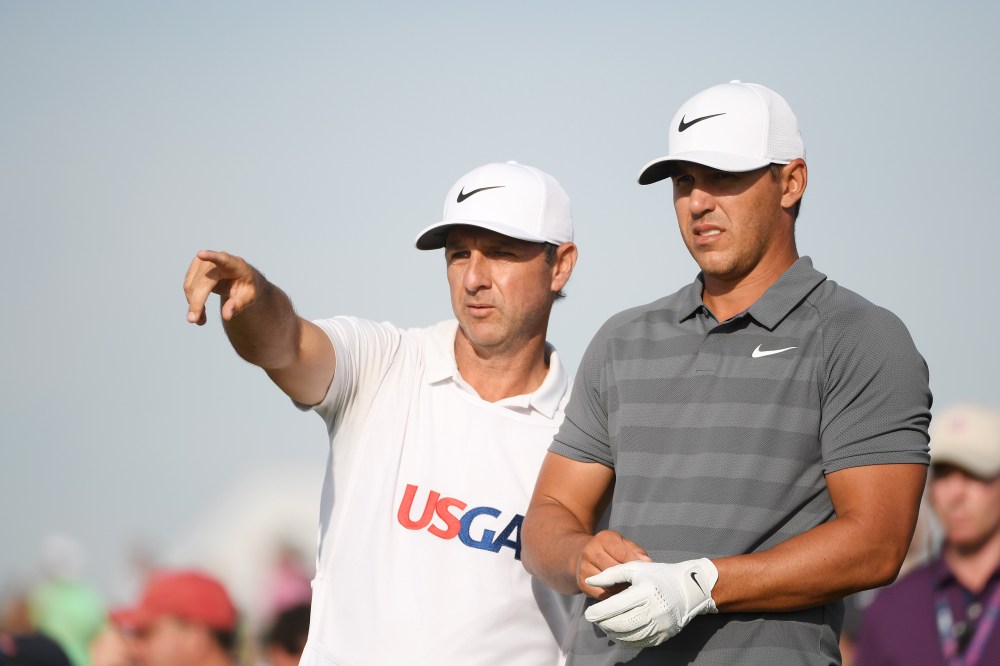 SOUTHAMPTON, NY - JUNE 17: Brooks Koepka of the United States talks with his caddie Richard Elliott on the 18th green during the final round of the 2018 U.S. Open at Shinnecock Hills Golf Club on June 17, 2018 in Southampton, New York. (Photo by Ross Kinnaird/Getty Images)
