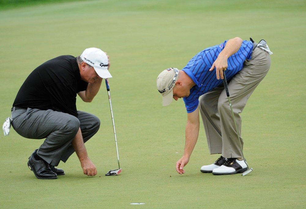 Paul Goydos and Ben Crane check out spike marks in 2009. (Chris Condon/PGA Tour)
