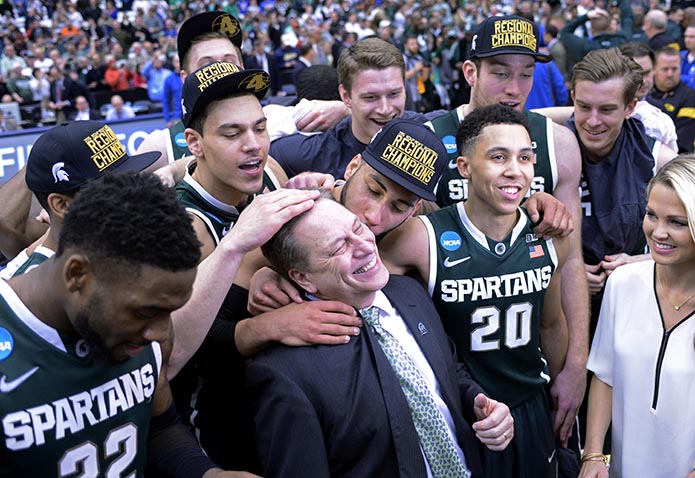 The Michigan State Spartans celebrates with head coach Tom Izzo after the game against the Louisville Cardinals in the finals of the east regional of the 2015 NCAA Tournament at Carrier Dome. The Michigan State Spartans won 76-70.