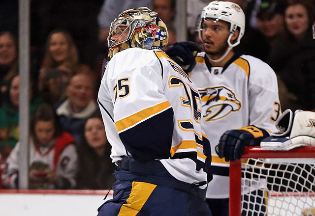 Pekka Rinne searches for a lost puck in his equipment. (Jonathan Daniel/Getty Images)
