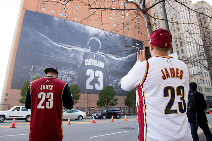 Fans take pictures of a LeBron James #23 of the Cleveland Cavaliers banner outside Quicken Loans Arena before a game against the New York Knicks on October 30, 2014 in Cleveland, Ohio. NOTE TO USER: User expressly acknowledges and agrees that, by downloading and or using this photograph, User is consenting to the terms and conditions of the Getty Images License Agreement.  (Photo by Jason Miller/Getty Images) ORG XMIT: 508084089 ORIG FILE ID: 458120638